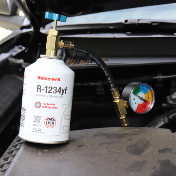 Zero R R1234YF refrigerant recharge kit - Genuine Honeywell HFO-R1234YF refrigerant attached to Zero R Can Tap in engine bay of vehicle with hood open